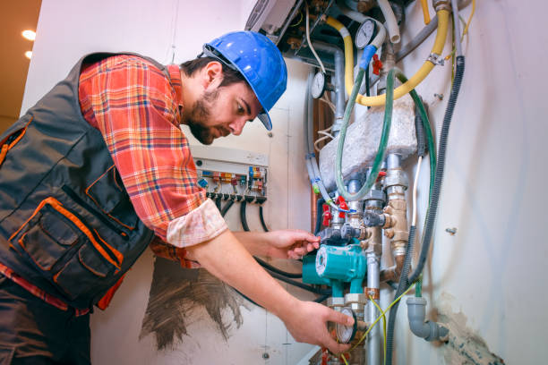 Technician inspects pipes and valves on a boiler system.